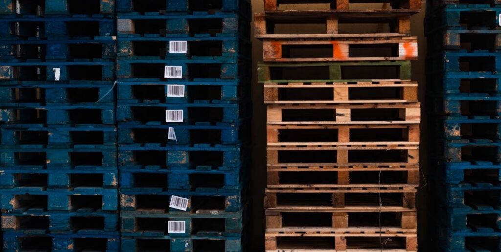 Stacks of blue and natural wood shipping pallets in a warehouse